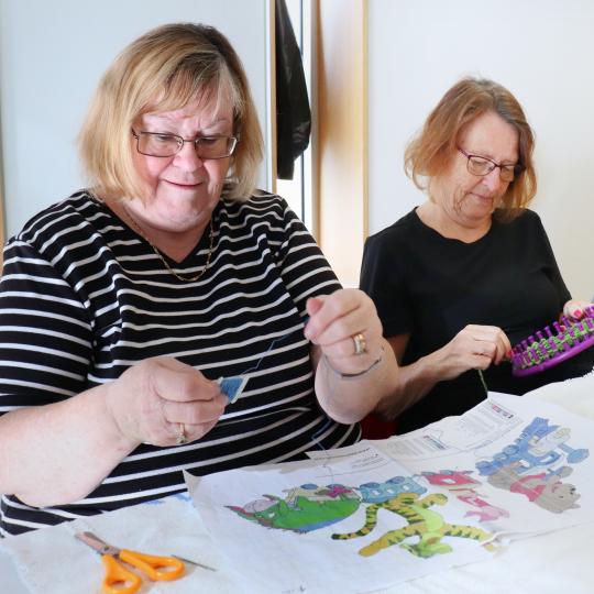 Two women crafting at the Crafters' Corner program. 