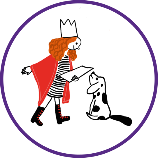 A girl with red hair, wearing a crown and a red cape reads to a black and white dog.